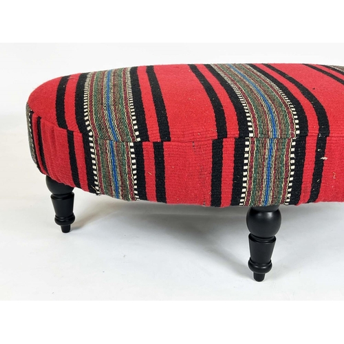 223 - HEARTH STOOL, 43cm H x 116cm W x 73cm D, ebonised of oval form in striped red flatweave upholstery.