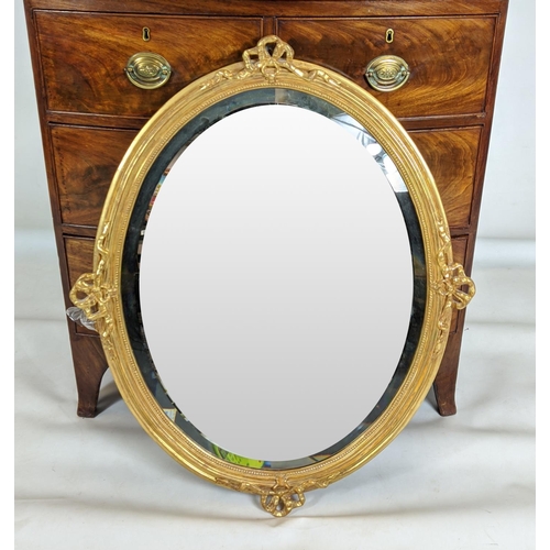 386 - OVAL MIRROR, with bevelled plate and a ribbon frame with ribbon detail, 86cm x 70cm.