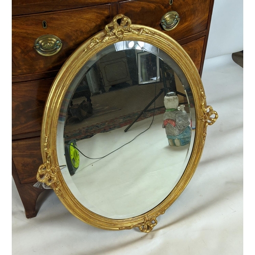 386 - OVAL MIRROR, with bevelled plate and a ribbon frame with ribbon detail, 86cm x 70cm.