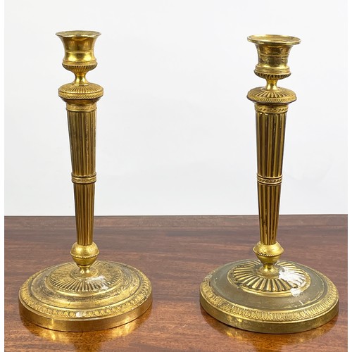 12 - CANDLESTICKS, a near pair, 19th century gilt brass, 27cm H. (2)