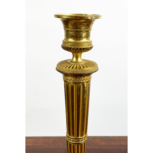 12 - CANDLESTICKS, a near pair, 19th century gilt brass, 27cm H. (2)