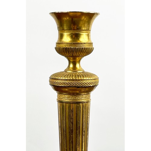 12 - CANDLESTICKS, a near pair, 19th century gilt brass, 27cm H. (2)