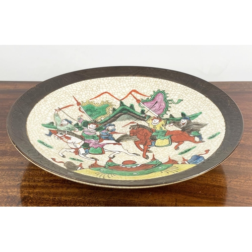 16 - CHINESE STONEWARE PLATE, decorated with battle scene in bright enamels, 33cm diam.