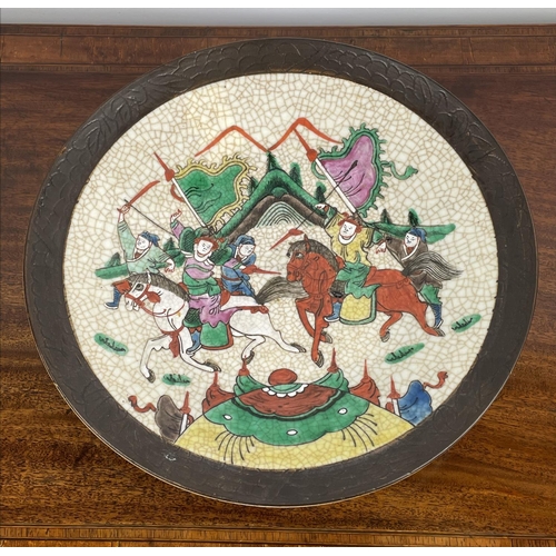 16 - CHINESE STONEWARE PLATE, decorated with battle scene in bright enamels, 33cm diam.