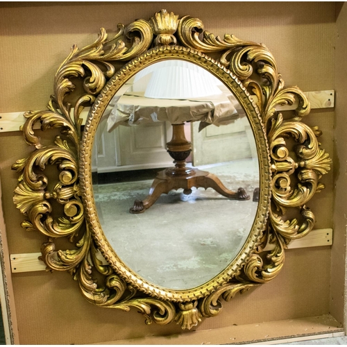 157 - OVAL WALL MIRROR, 128cm x 135cm H, 20th century with a scrolling giltwood frame and bevelled plate.