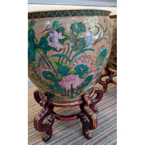 479 - PLANTERS ON STANDS, a pair, Chinese style ceramic, wooden stands, 72cm H x 55cm diam approx. (2)