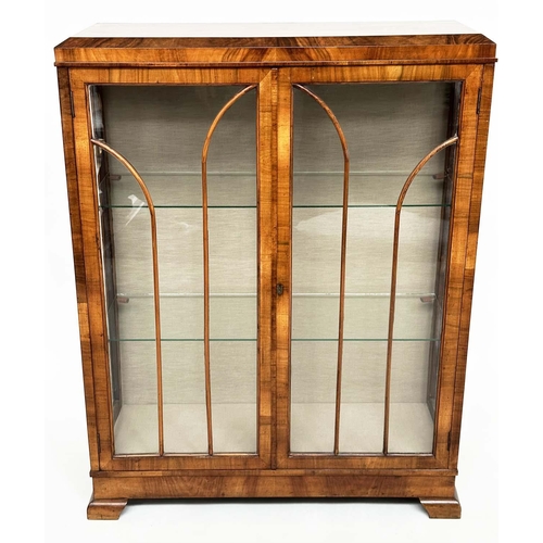 120 - ART DECO DISPLAY CASE, figured walnut with two arched glazed panelled doors enclosing glass shelves,... 