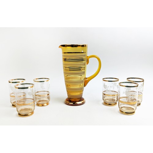 10 - A MID 20TH CENTURY MATCHED COCKTAIL SET, circa 1960, comprising a large amber coloured jug and six b... 