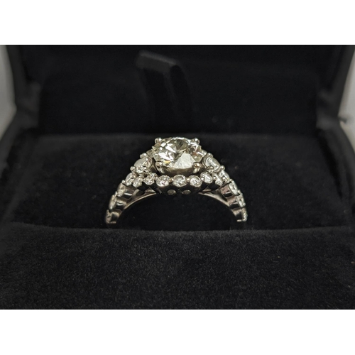 1 - A WHITE METAL DIAMOND SET DRESS RING, probably 18ct white gold, the large round brilliant cut centra... 