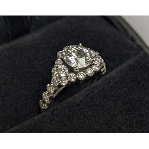 1 - A WHITE METAL DIAMOND SET DRESS RING, probably 18ct white gold, the large round brilliant cut centra... 