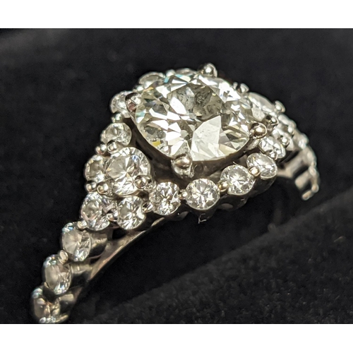 1 - A WHITE METAL DIAMOND SET DRESS RING, probably 18ct white gold, the large round brilliant cut centra... 