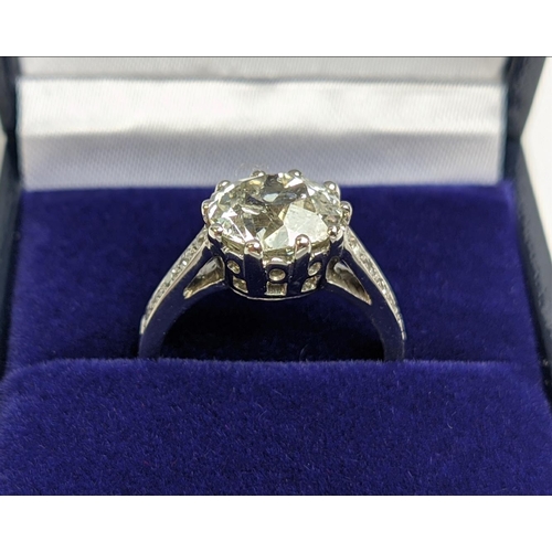 A PLATINUM AND DIAMOND SET SOLITAIRE RING, the single old mine cut diamond of approximately 2.81 carats, crown setting, diamond set shoulders, ring size L, complete with box and certificate.