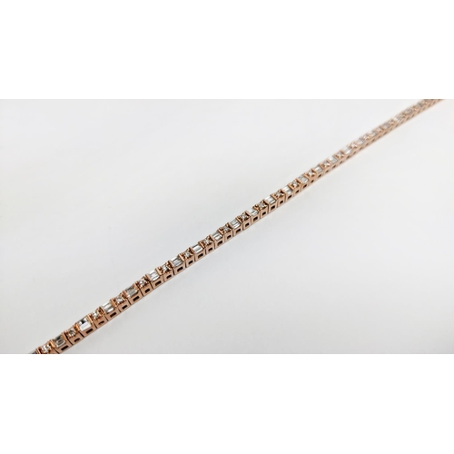 38 - A 10CT ROSE GOLD AND DIAMOND SET BRACELET, set with alternating baguette and round brilliant cut dia... 