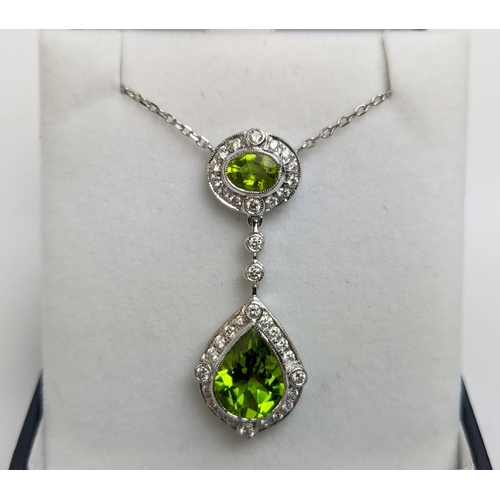 40 - AN 18CT WHITE GOLD PERIDOT AND DIAMOND SET PENDANT NECKLACE, the pear shaped drop pendant surrounded... 