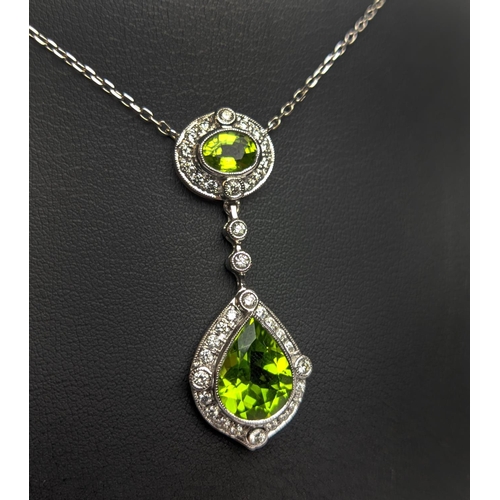 40 - AN 18CT WHITE GOLD PERIDOT AND DIAMOND SET PENDANT NECKLACE, the pear shaped drop pendant surrounded... 