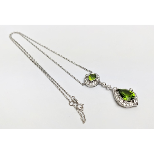 40 - AN 18CT WHITE GOLD PERIDOT AND DIAMOND SET PENDANT NECKLACE, the pear shaped drop pendant surrounded... 