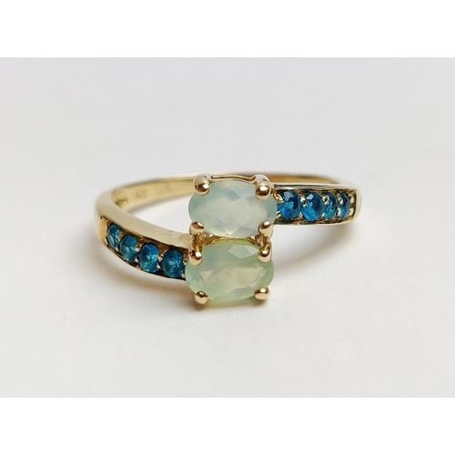 26 - A 9CT GOLD PREHNITE AND NEON APATITE CROSSOVER RING, to the shoulders, ring size P, boxed.