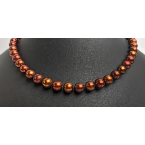 27 - A CULTURED PEARL SINGLE STRAND NECKLACE, fitted with 47 cocoa coloured pearls of approximately 7mm d... 