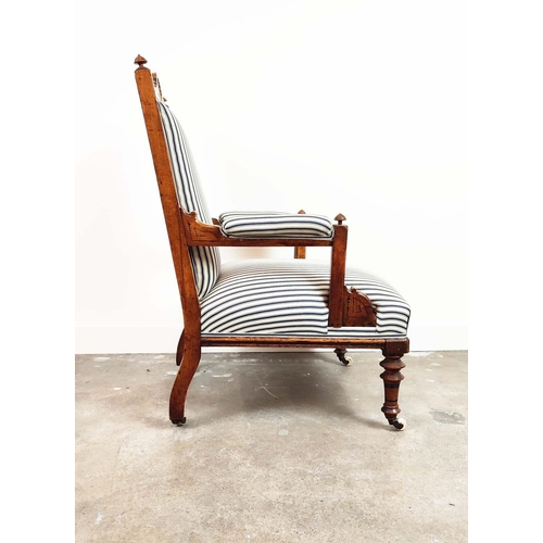 238 - AESTHETIC ARMCHAIR, Victorian oak and ebonised, circa 1870, in blue and white ticking on ceramic cas... 