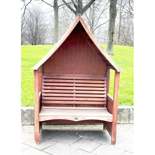 396 - ARBOUR SEAT, traditional form well weathered wood with slatted seat and boarded gable roof, 138cm x ... 