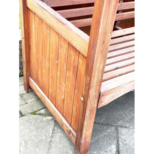 396 - ARBOUR SEAT, traditional form well weathered wood with slatted seat and boarded gable roof, 138cm x ... 