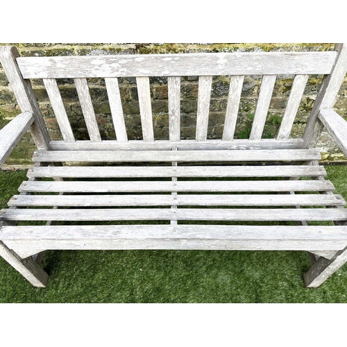 397 - GARDEN BENCH, silvery weathered teak of slatted construction, 130cm W, by 'Lister'.