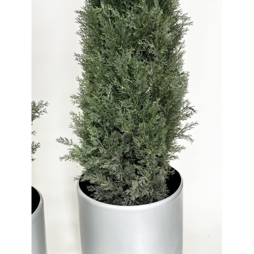 216 - ARTIFICIAL CONIFERS, a pair, in silvered metal drum planters, planters 49cm W, heights overall appro... 
