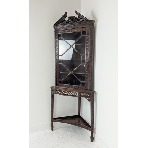 168 - GLAZED CORNER CABINET ON STAND, Edwardian mahogany in Chippendale style with door and carved fretwor... 