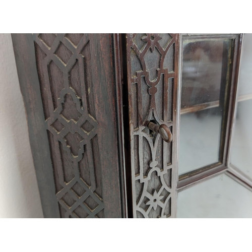 168 - GLAZED CORNER CABINET ON STAND, Edwardian mahogany in Chippendale style with door and carved fretwor... 