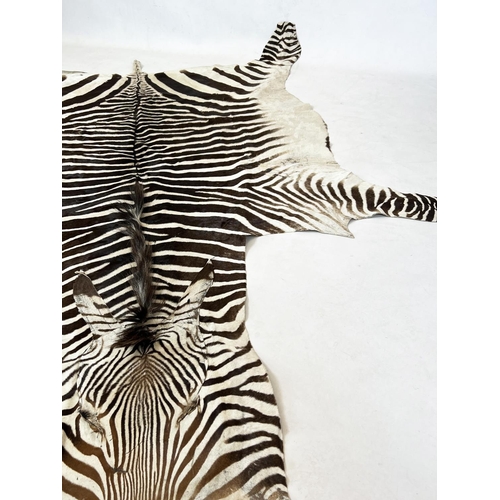 166 - ZEBRA SKIN RUG, early 20th century full hide with a baize lining, 290cm x 191cm approx.