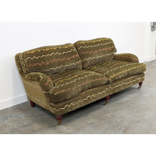 205 - HOWARD STYLE SOFA, two seater with geometric upholstery and turned front supports with brass castors... 