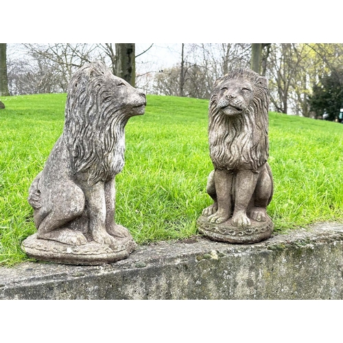 276 - GARDEN LIONS, a pair, well weathered reconstituted stone, seated, 57cm H. (2)