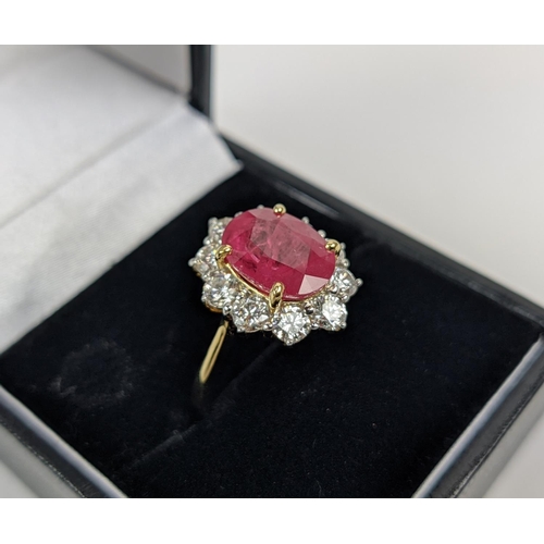 42 - AN 18CT GOLD RUBY AND DIAMOND CLUSTER RING, the mixed cut ruby of 4.11 carats, surrounded by ten rou... 