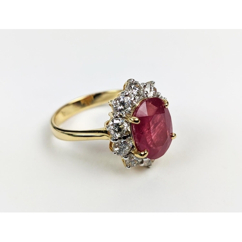 42 - AN 18CT GOLD RUBY AND DIAMOND CLUSTER RING, the mixed cut ruby of 4.11 carats, surrounded by ten rou... 