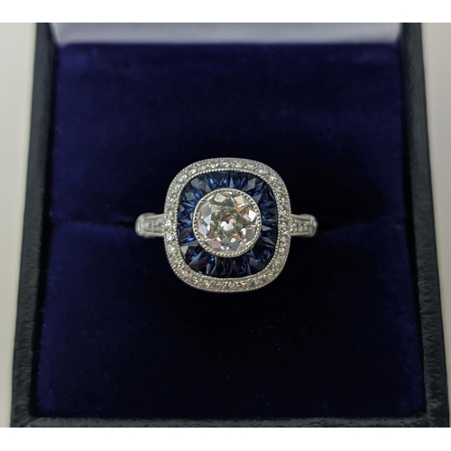 51 - A PLATINUM AND DIAMOND SOLITAIRE RING, the central old cut stone of approximately 0.85 carats, surro... 