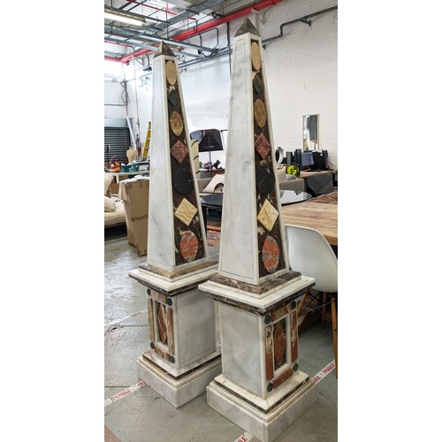 335 - MARBLE OBELISKS, a pair, large scale with various  stone applied decoration 182cm H x 40cm W. (2)