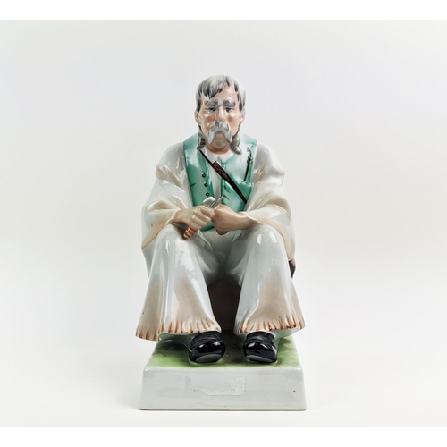 22 - A ZSOLNAY FIGURE OF A MAN WITH A KNIFE, seated, made in Hungary, hand painted, 33cm high