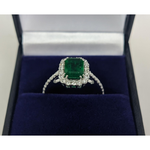 36 - AN 18CT WHITE GOLD EMERALD AND DIAMOND SET DRESS RING, the central step-cut emerald of approximately... 