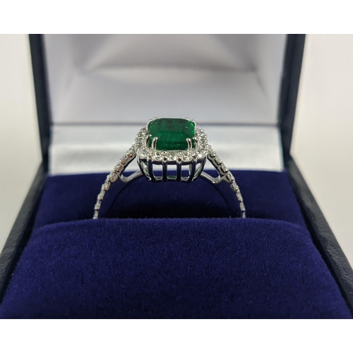 36 - AN 18CT WHITE GOLD EMERALD AND DIAMOND SET DRESS RING, the central step-cut emerald of approximately... 