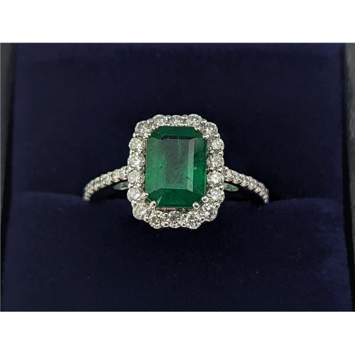 36 - AN 18CT WHITE GOLD EMERALD AND DIAMOND SET DRESS RING, the central step-cut emerald of approximately... 