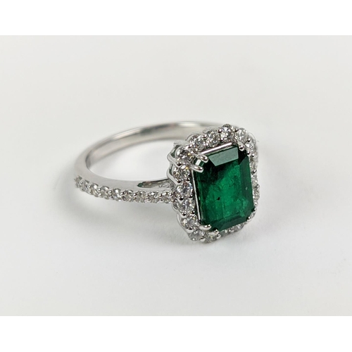 36 - AN 18CT WHITE GOLD EMERALD AND DIAMOND SET DRESS RING, the central step-cut emerald of approximately... 