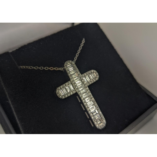 37 - A 18CT WHITE GOLD DIAMOND SET CROSS PENDANT, set with baguette cut diamonds and a border of round br... 