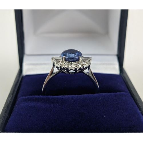 41 - AN 18CT WHITE GOLD SAPPHIRE AND DIAMOND HALO RING, the central oval mixed cut sapphire of approximat... 