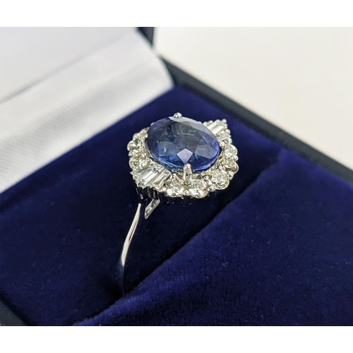 41 - AN 18CT WHITE GOLD SAPPHIRE AND DIAMOND HALO RING, the central oval mixed cut sapphire of approximat... 