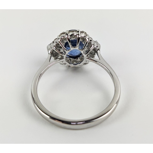 41 - AN 18CT WHITE GOLD SAPPHIRE AND DIAMOND HALO RING, the central oval mixed cut sapphire of approximat... 