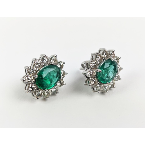 43 - A PAIR OF 18CT WHITE GOLD EMERALD AND DIAMOND CLUSTER STUD EARRINGS, the oval mixed cut emerald ston... 