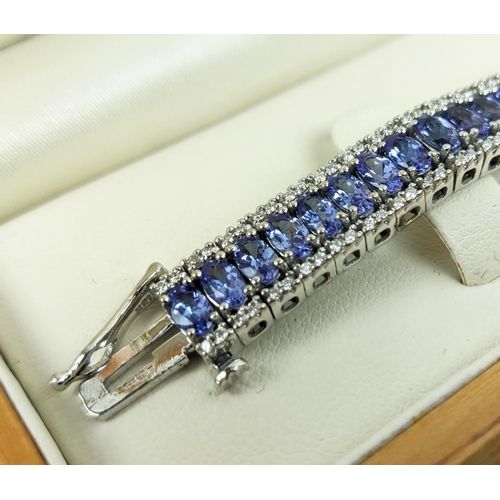 44 - AN 18CT WHITE GOLD TANZANITE AND DIAMOND BRACELET, set with sixty links, each link with a faceted ta... 