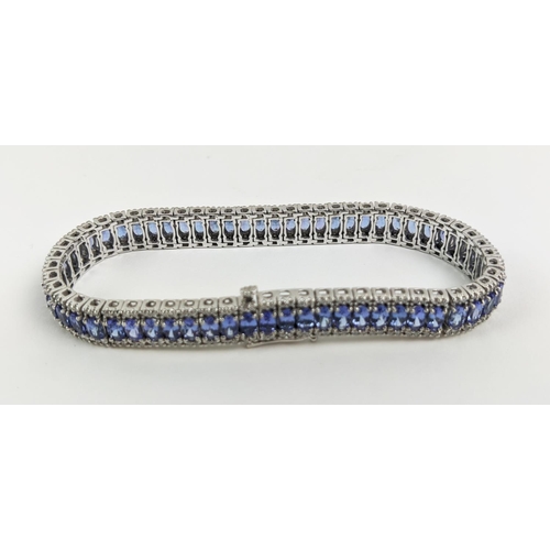 44 - AN 18CT WHITE GOLD TANZANITE AND DIAMOND BRACELET, set with sixty links, each link with a faceted ta... 