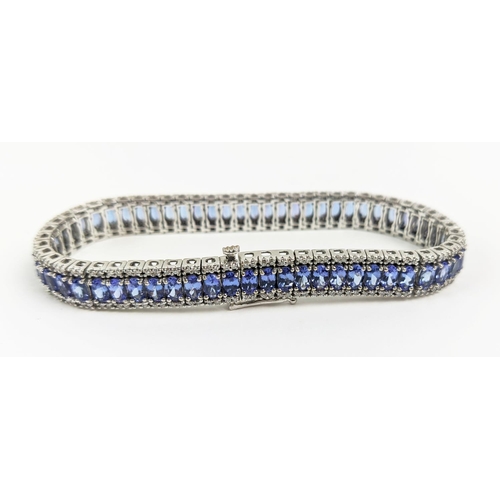 44 - AN 18CT WHITE GOLD TANZANITE AND DIAMOND BRACELET, set with sixty links, each link with a faceted ta... 