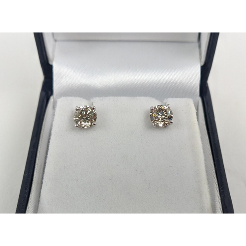 45 - A PAIR OF 18CT WHITE GOLD DIAMOND SOLITAIRE STUD EARRINGS, each with a claw set round brilliant cut ... 